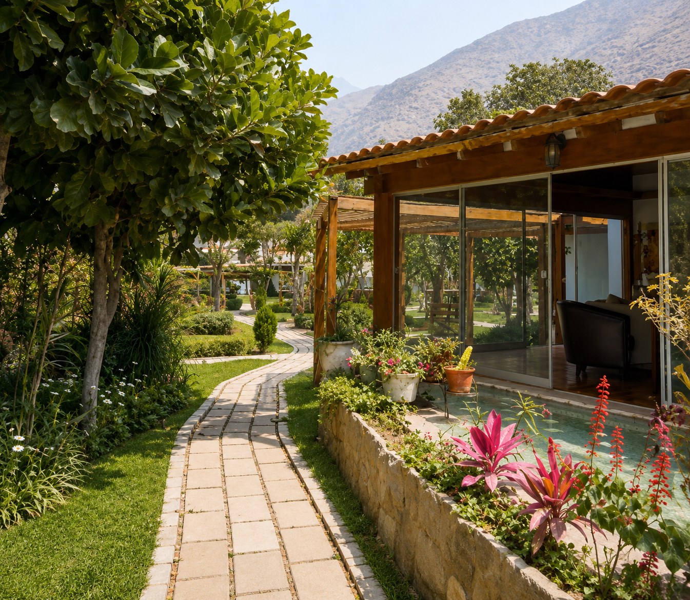 Jardín del club con camino de piedra, flores y las montañas de Santa Eulalia al fondo